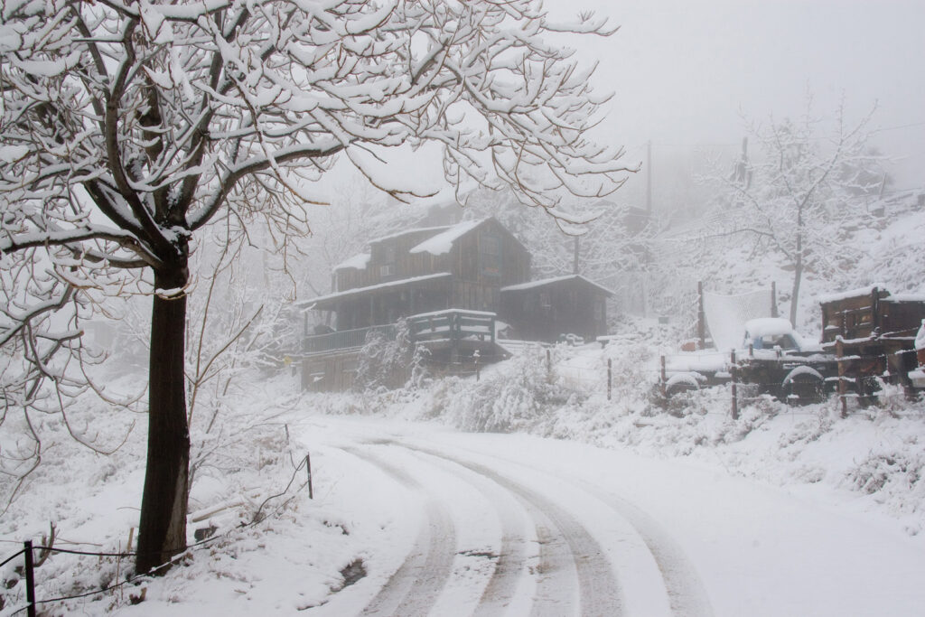 a house in the early morning fog after a snow fall